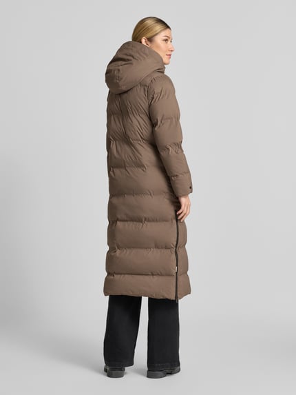 Frauenmodel trägt Steppmantel mit Reißverschlusstaschen Modell 'MAYLA4' von khujo in Braun, glatte Oberfläche, Ganzkörperansicht Rückansicht. Damen Steppmantel, Regular Fit, Kapuze, verdeckter Reißverschluss, Label-Detail, Maße laut Produktbeschreibung.