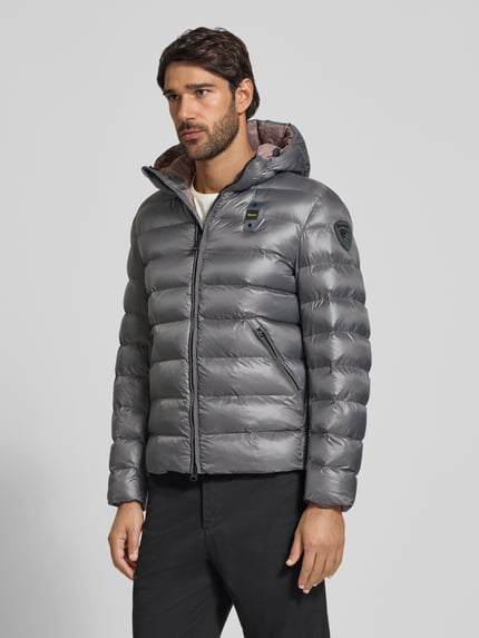 Männermodel trägt silbergraue Steppjacke mit Zweiwege-Reißverschluss Modell 'ADAMS' von Blauer USA, Regular Fit, Ganzkörperansicht von vorne.
