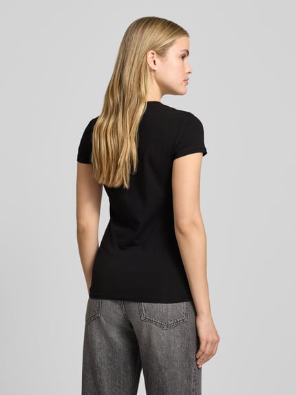 Vrouwenmodel draagt T-Shirt met Label-Print van ARMANI EXCHANGE, zwart, slim fit, katoen-elastaan, geribde ronde hals, ruglengte 60 cm, full-body achteraanzicht.