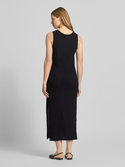 Frauenmodel trägt Maxikleid mit Rundhalsausschnitt Modell 'ZURI' von JJXX aus Reine Baumwolle, Körpernaher-Schnitt, Rückenlänge 131 cm, Brustweite 45 cm, schwarzer Stoff mit leichter Textur, Ganzkörperansicht Rückansicht.