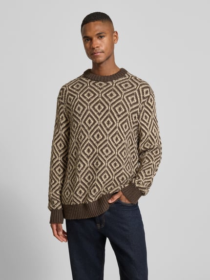 Männermodel trägt Relaxed Fit Strickpullover aus Woll-Mix Modell 'REMI' von SELECTED HOMME mit Allover-Muster, Nahaufnahme Oberkörper.