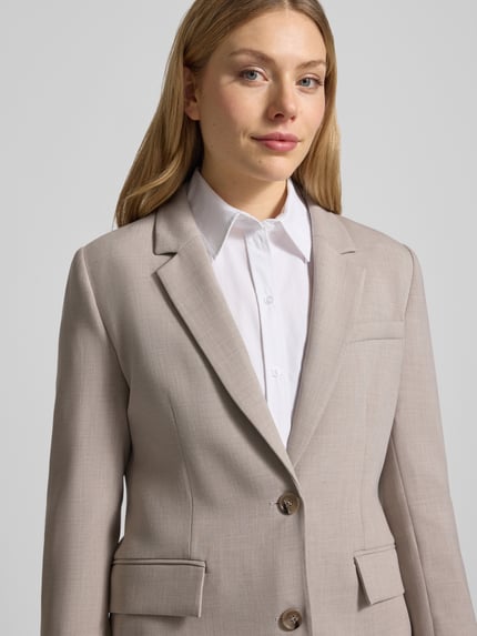 Frauenmodel trägt Regular Fit Blazer mit Viskose-Anteil Modell 'RITA' von Selected Femme, Optik: Unifarben, Melange, 2-Knopf-Verschluss, Reverskragen, Pattentaschen, Materialverarbeitung: Webware, Material-Mix mit Viskose-Anteil, Nahaufnahme Oberkörper.