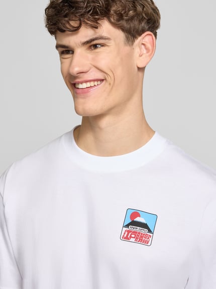Männermodel trägt Herren T-Shirt von Edwin aus Reine Baumwolle, Weiß mit Label-Print, Rundhalsausschnitt, Relaxed-Fit, Nahaufnahme Oberkörper. Modell 'SUNSET ON FUJI SAN', Rückenlänge bei Größe M: 69 cm.