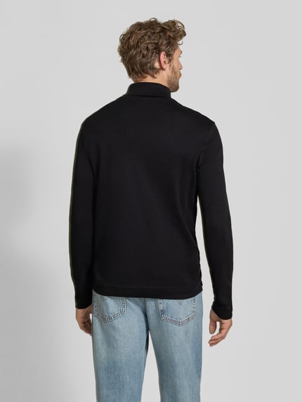 Männermodel trägt Regular Fit Longsleeve aus reiner Baumwolle mit Rollkragen von Christian Berg Men, schwarze Farbe, glatte Struktur, elastische Abschlüsse, Rückenlänge bei Größe M 70 cm, Ganzkörperansicht Rückansicht.