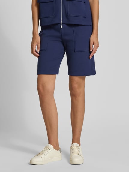 Kobiece modelka nosi Regular Fit Shorts mit elastischem Bund od Christian Berg Woman, elastyczna mieszanka materiałów, ozdobne szwy, krój regular fit, pas elastyczny, widok z przodu, ujęcie całej sylwetki