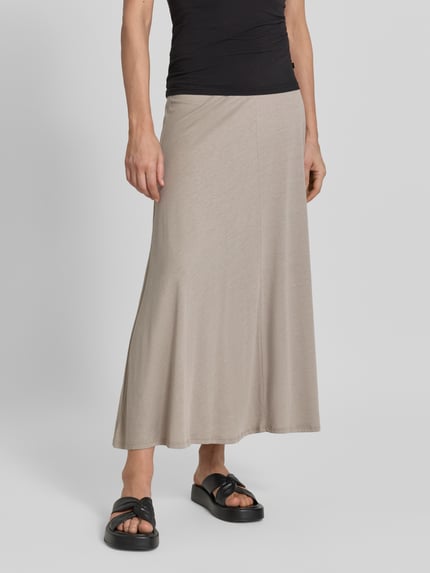 Frauenmodel trägt Loose Fit Midi-Rock aus Lyocell-Baumwoll-Mix Modell 'ILENIAA LARAA' von Armedangels in Beige, Ganzkörperansicht von vorne. Damen Midi-Rock von Armedangels.
