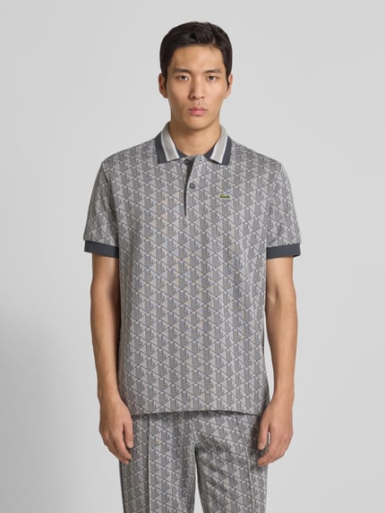 Männermodel draagt Regular Fit Poloshirt met katoen van Lacoste, look: effen, all-over monogrammotief, logodetail, jacquard, voorkant geheel.