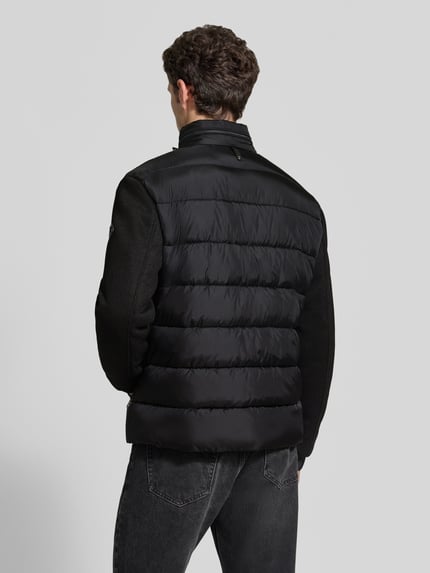 Männermodel trägt Regular Fit Steppjacke mit Stehkragen Modell 'Ciscos' von JOOP! COLLECTION in Schwarz, Ganzkörperansicht Rückansicht.