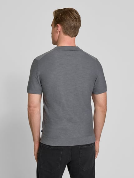 Männermodel trägt Regular Fit Poloshirt aus reiner Baumwolle von s.Oliver RED LABEL, Optik: Unifarben, Strick, Ganzkörperansicht Rückansicht.