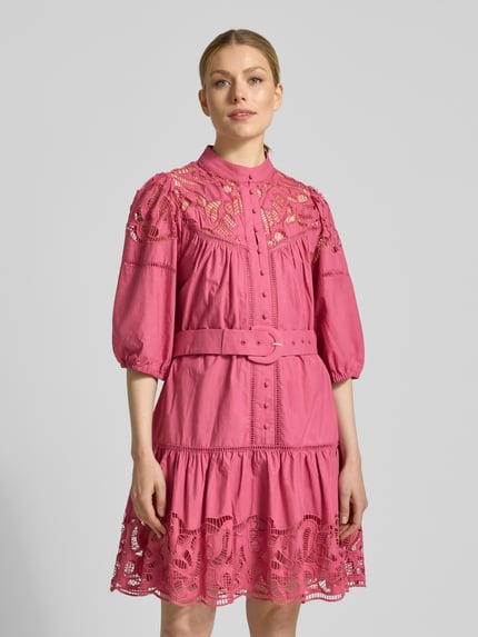 Vrouwenmodel draagt knielange jurk met kant en riem model 'CATY' van SUNCOO PARIS in roze, getailleerde fit, katoen, geheel van voren.