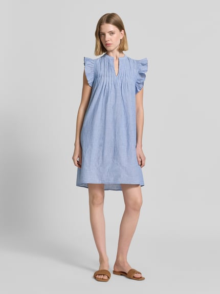 Vrouwenmodel draagt knielengte dames jurk van puur katoen, loose fit, serafinokraag, mouwen met ruches, model 'Gemala' van mbyM, volledig beeld van voren