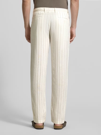 Męski model nosi Regular Fit Hose aus Leinen-Viskose-Mix von MCNEAL, kremowe spodnie z wpuszczanymi i tylnymi kieszeniami, szerokość w rozmiarze M: 46 cm, długość wewnętrzna nogawki: 84 cm, mieszanka lnu i wiskozy, krój regular fit, widok całej sylwetki z tyłu.