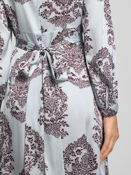 Frauenmodel trägt Maxikleid mit V-Ausschnitt Modell 'Bretti' von Neo Noir, Satin, florales Muster, Detailaufnahme Rücken, KI-modifiziertes Bild.