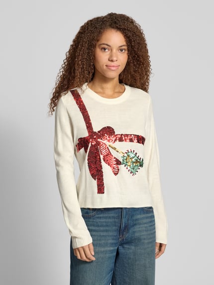 Frauenmodel trägt Rollkragenpullover mit weihnachtlichem Motiv-Print von ONLY, mehrfarbig, Strickoptik, Glitzer- und Pailletten-Print, Ganzkörperansicht von vorne.
