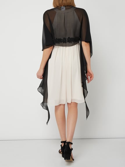 Frauenmodel trägt Stola aus Chiffon mit Knopfverschluss von Vera Mont, fließender Stoff in Schwarz, Ganzkörperansicht Rückansicht.
