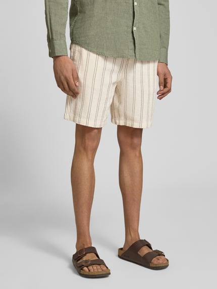 Männermodel trägt Regular Fit Shorts mit Tunnelzug von Jack & Jones aus reiner Baumwolle, Gesäßtasche, cremefarben, Nahaufnahme Unterkörper.