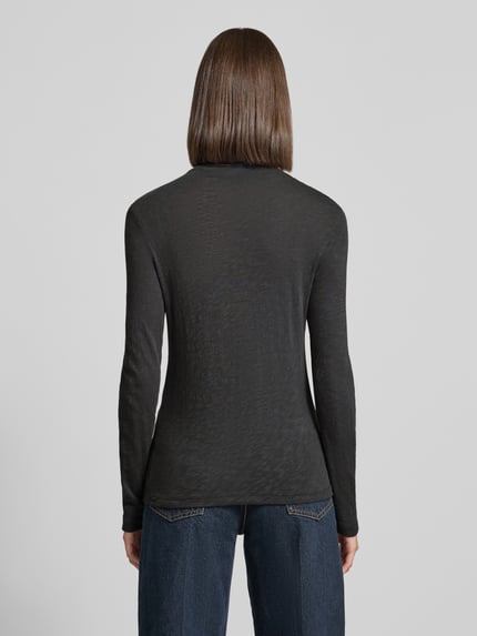 Frauenmodel trägt Langarmshirt mit Mock Neck Jersey von MARC O'POLO in Melange-Optik, strukturierte Oberfläche, Ganzkörperansicht Rückansicht.