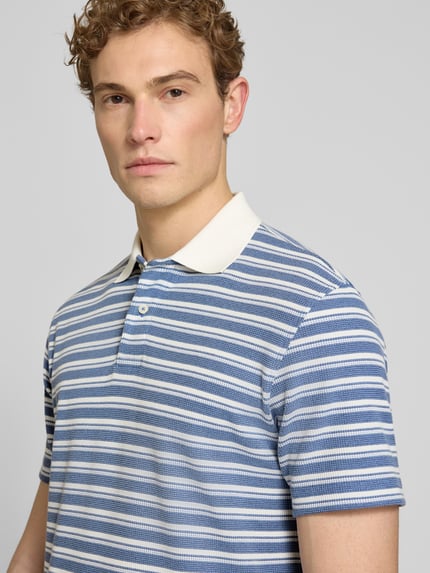 Mężczyzna nosi Regular Fit Poloshirt aus Baumwoll-Mix Modell 'BLAZE' od SELECTED HOMME, niebiesko-białe paski, materiał piqué, krój regular fit, krótki rękaw, polokragen, optyka jednolita, półzbliżenie przód.