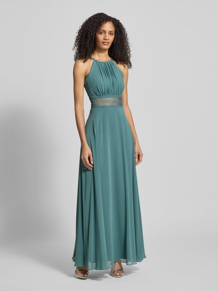 Frauenmodel trägt Abendkleid mit Raffungen von Jake*s Cocktail, taillierter Schnitt, Spaghettiträger, blickdichtes Unterkleid, Nahtreißverschluss, smaragdgrüne Farbe, fließender Stoff, Ganzkörperansicht von vorne.