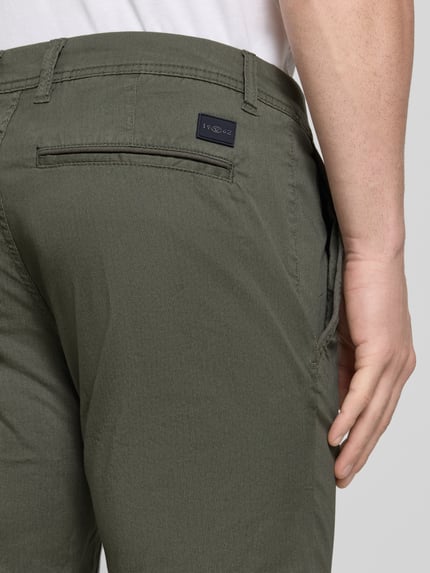 Männermodel trägt Slim Fit Chinoshorts aus Baumwoll-Mix von Tom Tailor, Optik:Allover-Muster, Materialverarbeitung: Twill, Ganzkörperansicht Rückansicht.