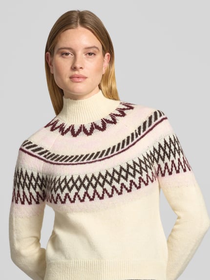Frauenmodel trägt Pullover mit Jacquardpasse Modell 'VMMAPLE' von VERO MODA, mehrfarbig mit geometrischem Rautenmuster, Strickoptik, hochgeschlossen, langarm, gerippte Abschlüsse, Ganzkörperansicht von vorne.