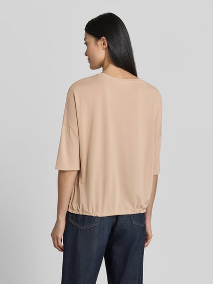 Frauenmodel trägt T-Shirt aus Modal-Mix mit Tunnelzug von Christian Berg Woman in Beige, Relaxed-Fit, Rückenlänge 55 cm, Ganzkörperansicht Rückansicht.
