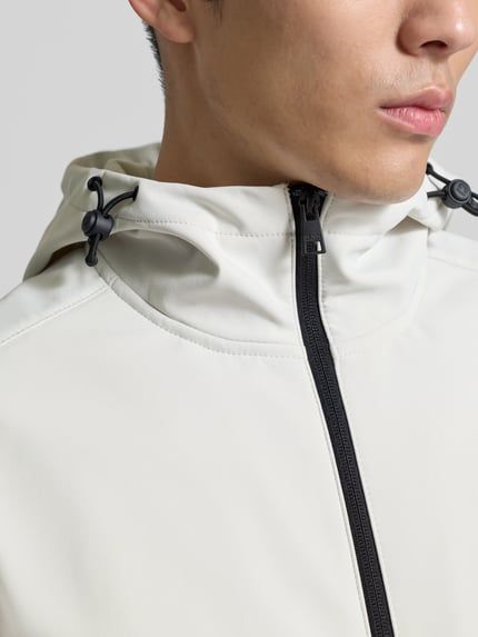 Männermodel trägt Regular Fit Funktionsjacke mit Kapuze von Tom Tailor Denim in Unifarben, wasser- und winddicht, Nahaufnahme Oberkörper.
