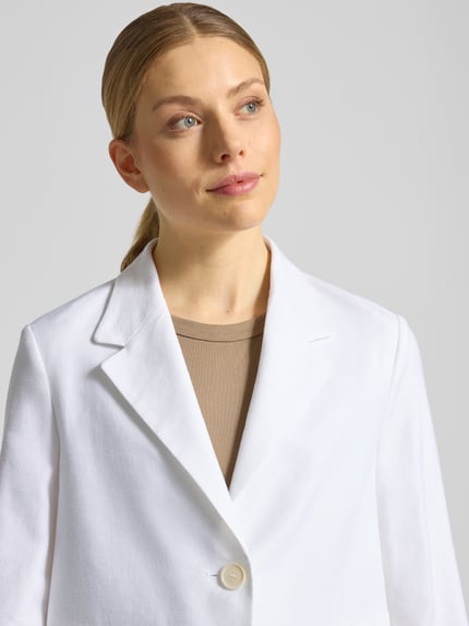Vrouwenmodel draagt Blazer aus Leinen-Mix mit Reverskragen van Windsor in wit linnenmix, regular fit, knoopsluiting, klepzakken, trompetmouwen, ruglengte 52 cm, borstwijdte 45 cm, mouwlengte 54 cm, nahaufnahme bovenlichaam.