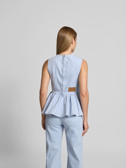 Vrouwenmodel draagt Slim Fit Top in Denim-Optik van BAUM & PFERDGARTEN, lichtblauw met rüschen, katoenmix, rugrits, rugaanzicht, ganzebody.