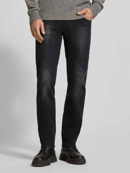 Männermodel trägt Jeans im Used-Look Modell 'Chuck' von Brax, Regular Fit, Baumwoll-Mix, dunkler Farbton, Eingrifftaschen, Ganzkörperansicht von vorne.