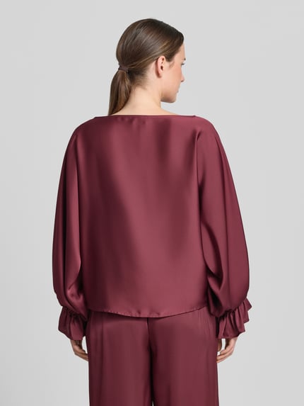 Frauenmodel trägt Blusenshirt aus Satin mit Rundhalsausschnitt von V by Vera Mont, bordeauxrot, glatte Textur, krój regular fit, Trompetenärmel, długość tyłu 58 cm, długość rękawa 63 cm, Ganzkörperansicht Rückansicht