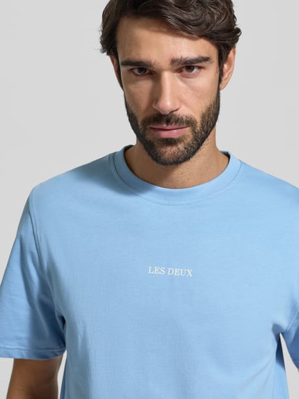 Männermodel trägt Herren T-Shirt mit Rundhalsausschnitt Modell 'Andrew' von Les Deux, Reine Baumwolle, Regular-Fit, Logo, Nahaufnahme Oberkörper.