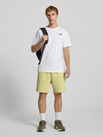 Männermodel trägt Sweatshorts mit Logo-Stitching von The North Face aus Reine Baumwolle, Relaxed-Fit, Bundweite 40 cm, Ganzkörperansicht von vorne.