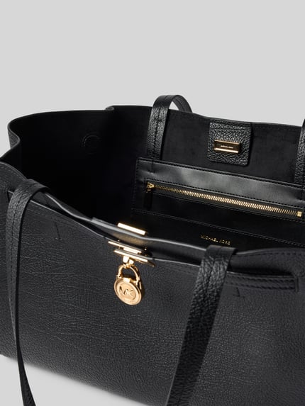 Produktfoto, zwarte Handtasche aus echtem Leder Modell 'HAMILTON' van MICHAEL Michael Kors met Labelapplicatie, hoofdvak met magneetsluiting, schouderband, breedte maat 1: 52 cm, lengte 27 cm, diepte 15 cm, schouderbandlengte 62 cm, detailopname, damescontext