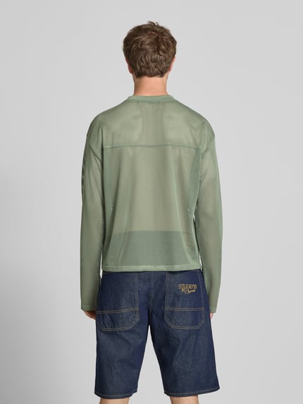 Męski model ma na sobie Longsleeve mit Label-Patch und Rundhalsausschnitt od KARL KANI, boxy fit, logo, kolor khaki, zdjęcie całej sylwetki z tyłu.