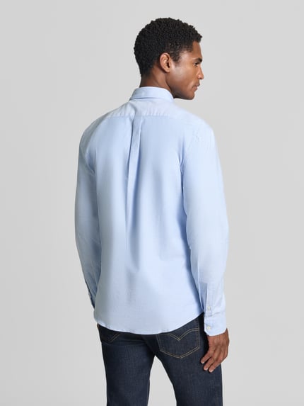 Männermodel trägt Regular Fit Freizeithemd aus Baumwoll-Mix Modell 'Oxford' von Lindbergh in Hellblau, Rückenansicht, Ganzkörperansicht Rückansicht. Baumwoll-Elasthan-Mix, Button-Down-Kragen, 1-Knopf-Manschetten, abgerundeter Saum, Größe M: Rückenlänge 77 cm, Schulterbreite 44 cm, Ärmellänge 66 cm.
