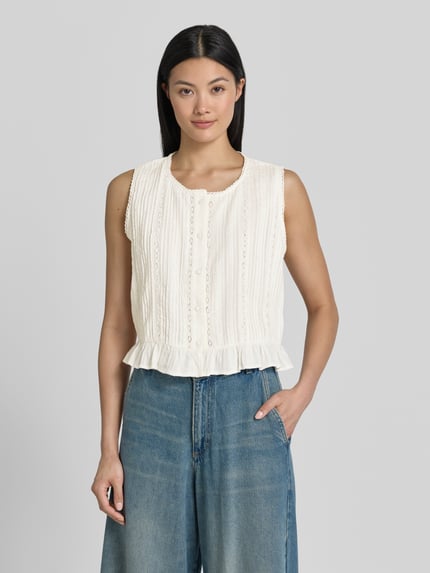 Kobiece modelka nosi Blusentop mit Knopfleiste und Häkelspitze od Jake*s Casual, bawełna, krój regular fit, okrągły dekolt, listwa guzikowa, szydełkowa koronka, długość tyłu w rozmiarze 36: 46 cm, jasny kremowy kolor, faktura koronkowa, gładkie dżinsy, całopostaciowy widok z przodu.
