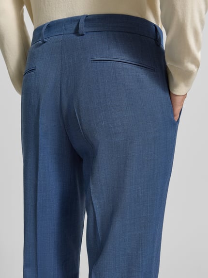 Männermodel trägt Regular Fit pantalon met scheerwol model 'LEON' van BOSS, all-over structuurpatroon look, zij-steekzakken, labelapplicatie, riemlussen, haak- en ritssluiting, achterzakken, detailopname rugaanzicht