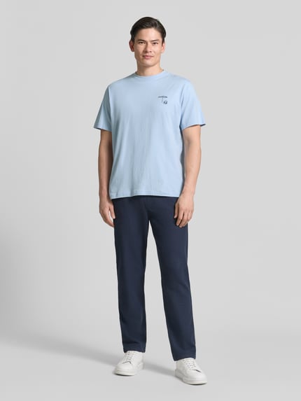 Männermodel trägt Regular Fit T-Shirt aus reine katoen Modell 'HASPEN' van SELECTED HOMME, lichtblauw, effen, motief-stitching, ronde hals, korte mouw, jerseystof, geheellichaamsaanzicht van voren.