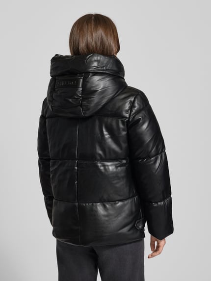 Frauenmodel trägt schwarze Steppjacke mit Kapuze Modell 'AURORA' von khujo, Regular-Fit, Label-Detail, Rückenlänge Größe S: 65 cm, Ganzkörperansicht Rückansicht.