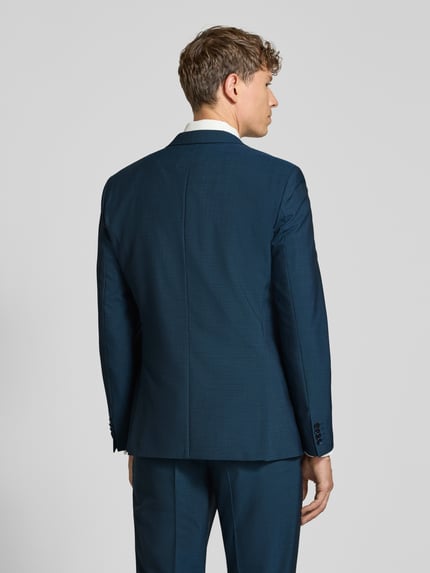 Männermodel trägt Regular Fit Anzug aus Wolle mit Bundfalte von HUGO, unifarben mit feinem Webstruktur, Ganzkörperansicht Rückansicht.
