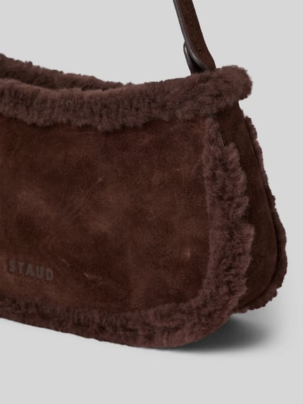 Produktfoto, braune Handtasche mit Teddyfell Modell 'OLLIE' von Staud mit Reißverschluss, Label-Detail und breitem Tragehenkel, Detailaufnahme
