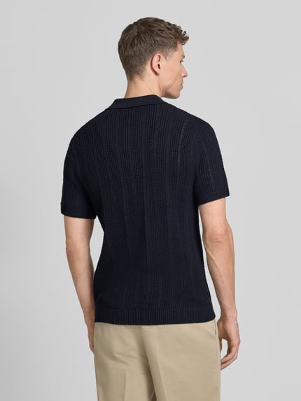 Männermodel trägt Slim Fit Poloshirt mit Knopfleiste von Jack & Jones Premium aus dunkelblauem Baumwoll-Mix, Rückenlänge 72 cm, Ganzkörperansicht Rückansicht.