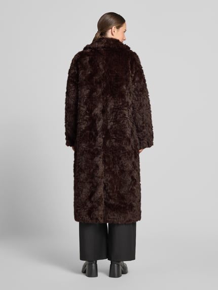 Frauenmodel trägt Teddymantel mit kuscheliger Webpelzstruktur von RICH&ROYAL in dunkelbrauner Fleece-Optik, Ganzkörperansicht Rückansicht.