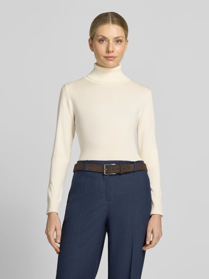 Frauenmodel trägt Slim Fit sweter z dzianiny z mieszanka wiskozy Modell 'IHLULS' od ICHI, Golf, elastyczne wykończenia, Długość tyłu w rozmiarze S: 61 cm, Długość rękawów w rozmiarze S: 66 cm, jasny kolor, prosta faktura, Ganzkörperansicht von vorne.
