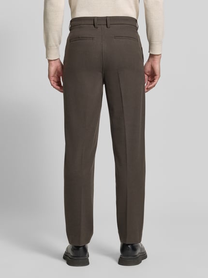Männermodel trägt Straight Fit Stoffhose mit Viskose-Anteil von Lindbergh, braune Farbe, Bügelfalten, Rückansicht, Herrenmode, Ganzkörperansicht Rückansicht.