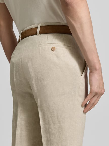 Männermodel trägt Slim Fit Leinenhose mit Woll- und Viskose-Anteil Modell 'Shiver' von Carl Gross, helle Beige-Töne, feine Textur, Nahaufnahme Rückansicht, Herren Leinenhose, Leinen-Mix mit Woll-Anteil und Viskose-Anteil, Bügelfalten, Eingriffstaschen, Gesäßtasche, Knopf- und Reißverschluss, Bundweite 45 cm, Innenbeinlänge 81 cm.