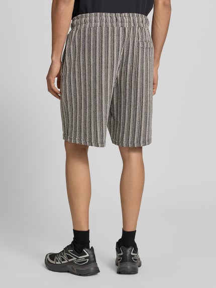 Männermodel trägt Straight Fit Shorts mit Strukturmuster Modell 'Forno' von Pegador aus Reine Baumwolle, Ganzkörperansicht Rückansicht.