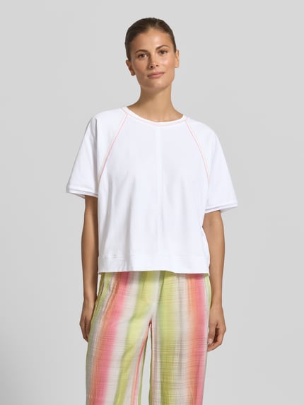 Frauenmodel trägt Relaxed Fit T-Shirt mit Rundhalsausschnitt von Marc Cain aus Reine Baumwolle mit Ziernähte, Rückenlänge 52 cm, Ganzkörperansicht von vorne.
