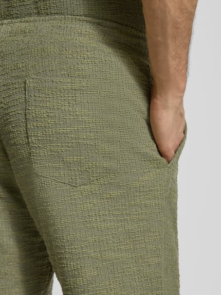 Männermodel trägt Shorts mit elastischem Bund von MCNEAL aus Material-Mix mit Strukturmuster, Regular-Fit, Detailaufnahme Gesäß.